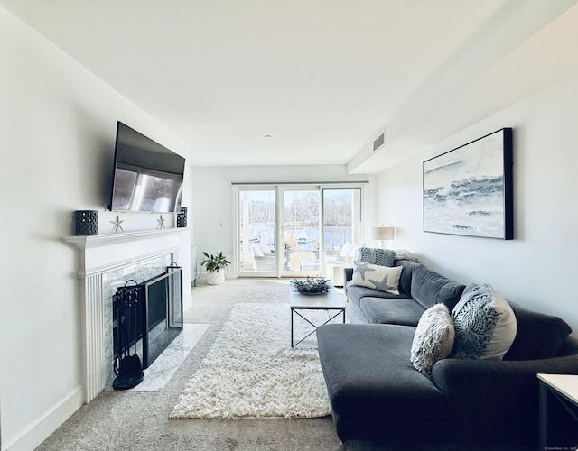 carpeted living room with a premium fireplace