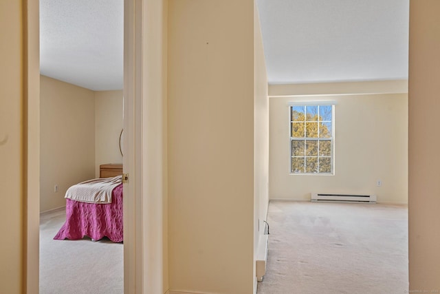 hall featuring light colored carpet, a textured ceiling, and a baseboard heating unit