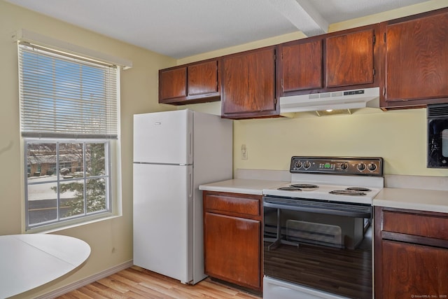 kitchen with black microwave, light wood-type flooring, white fridge, and range with electric stovetop