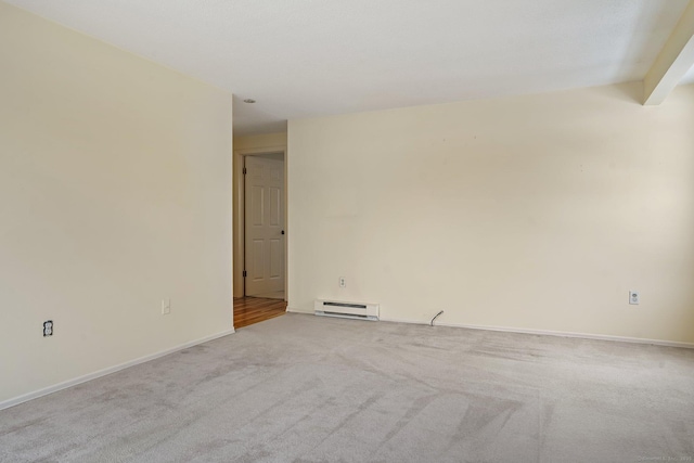 spare room featuring light carpet and baseboard heating