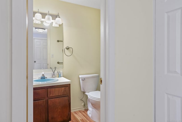 bathroom with vanity, wood-type flooring, and toilet