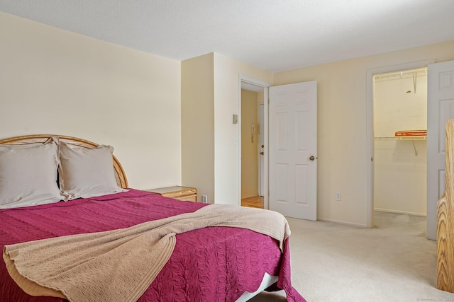 bedroom with a spacious closet and carpet