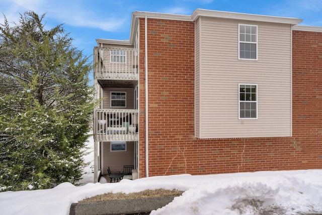 view of snowy exterior with a balcony