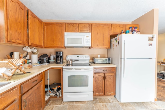 kitchen featuring a textured ceiling and white appliances