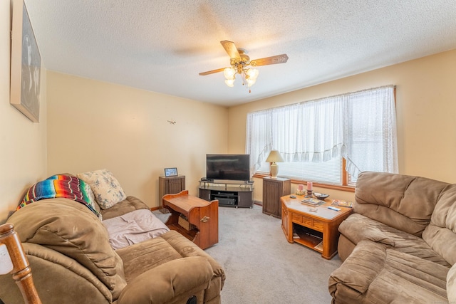 carpeted living room with ceiling fan and a textured ceiling