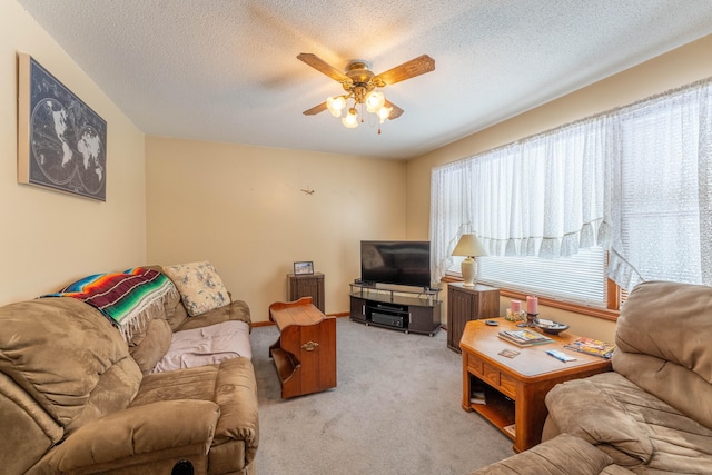 living room featuring ceiling fan, light carpet, and a textured ceiling