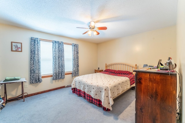 bedroom featuring ceiling fan, light colored carpet, and a textured ceiling