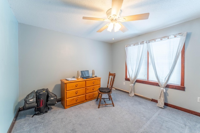 carpeted home office featuring ceiling fan and a textured ceiling