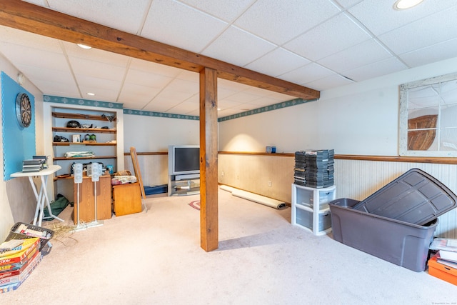 basement featuring a paneled ceiling and carpet flooring