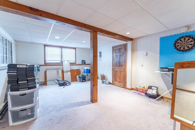 basement with a drop ceiling and carpet flooring