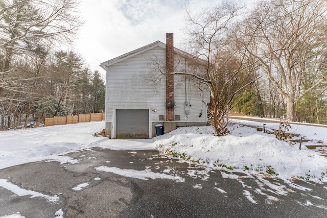 view of snow covered exterior with a garage