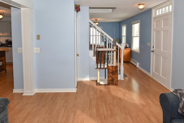 entryway featuring a baseboard heating unit and light hardwood / wood-style flooring