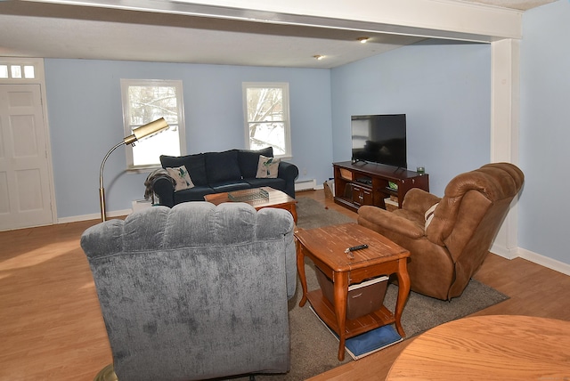 living room with light hardwood / wood-style flooring and a baseboard heating unit