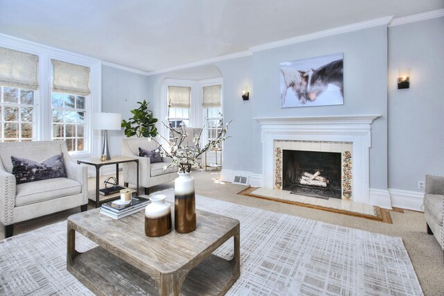 carpeted living room featuring crown molding, visible vents, a fireplace, and baseboards