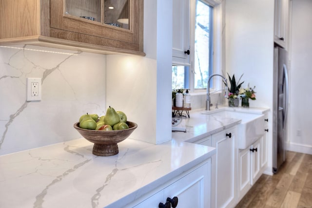 interior space featuring light wood-type flooring, a sink, and freestanding refrigerator