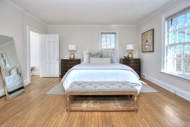 bedroom featuring light wood-style flooring, multiple windows, and crown molding