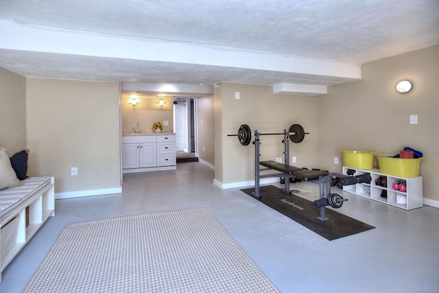 workout room featuring baseboards and a textured ceiling