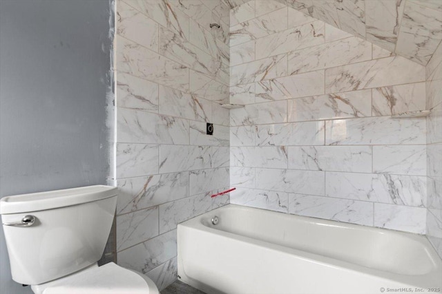 bathroom with tiled shower / bath combo and toilet