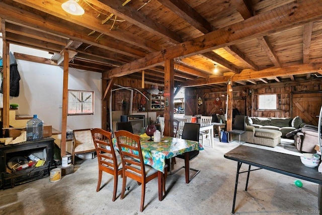 dining area with beamed ceiling, wood ceiling, and a wood stove