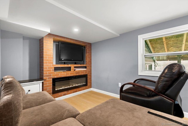 living room featuring wood-type flooring and a brick fireplace