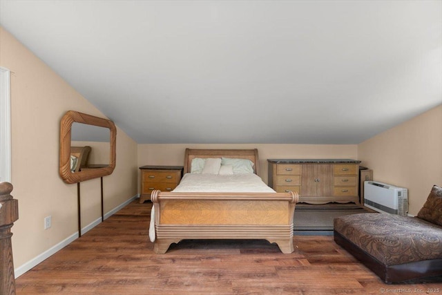 bedroom with lofted ceiling, dark wood-type flooring, and a wall unit AC