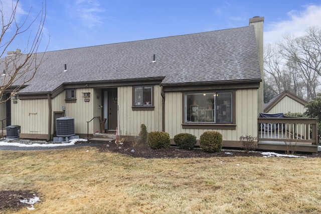 view of front of property with a front yard and central AC unit