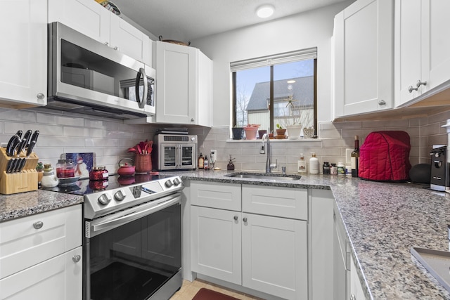 kitchen featuring appliances with stainless steel finishes, sink, and white cabinets