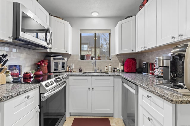 kitchen featuring appliances with stainless steel finishes, sink, and white cabinets