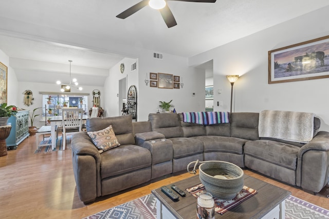 living room with hardwood / wood-style flooring and ceiling fan with notable chandelier