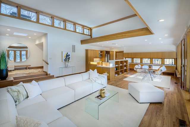 living room with light hardwood / wood-style floors and a high ceiling