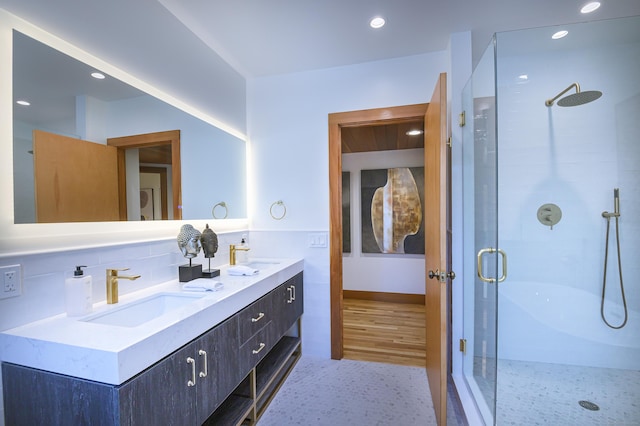 bathroom with vanity, tile walls, and a shower with shower door