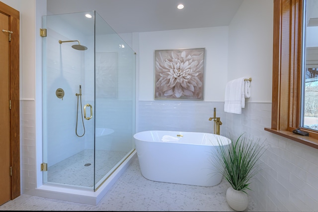 bathroom featuring separate shower and tub and tile walls