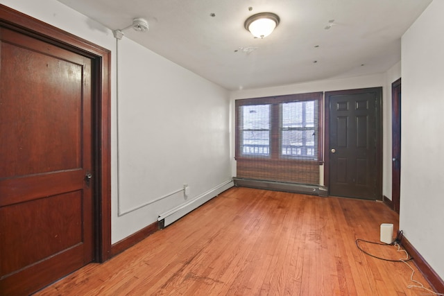 foyer entrance featuring a baseboard radiator and light hardwood / wood-style flooring