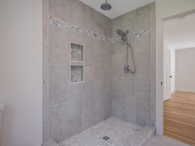 bathroom featuring hardwood / wood-style floors and tiled shower