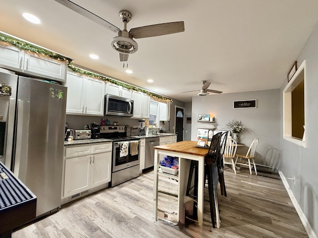 kitchen featuring sink, ceiling fan, white cabinetry, stainless steel appliances, and light hardwood / wood-style floors