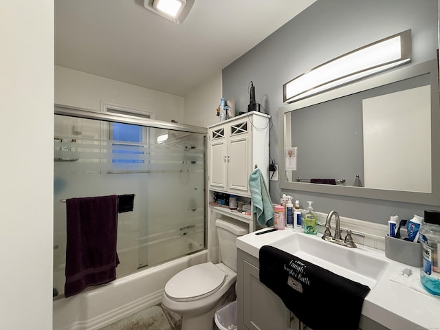 full bathroom featuring vanity, toilet, and combined bath / shower with glass door