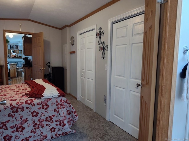 bedroom featuring crown molding, lofted ceiling, and carpet floors