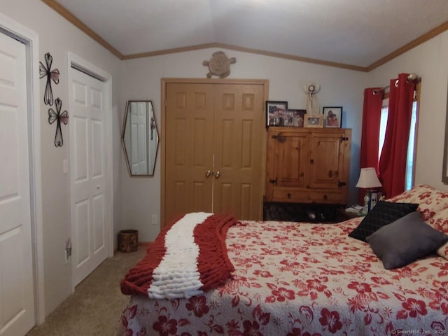 bedroom with multiple closets, ornamental molding, carpet floors, and vaulted ceiling