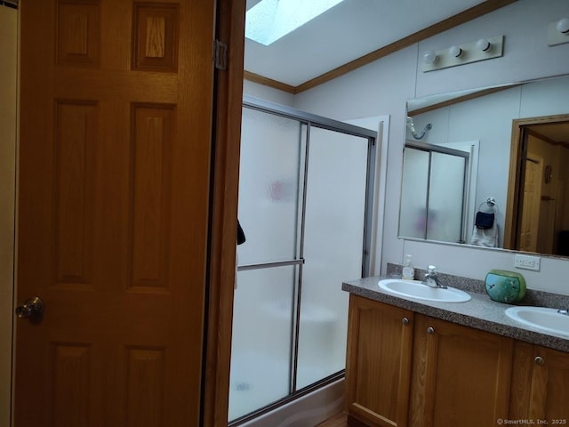 bathroom with vanity, ornamental molding, an enclosed shower, and a skylight