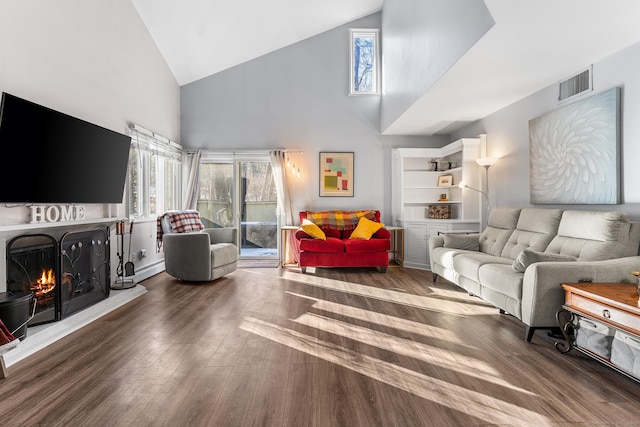 living room featuring dark hardwood / wood-style flooring and high vaulted ceiling