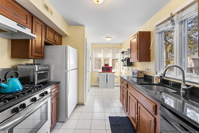 kitchen with sink, light tile patterned floors, stainless steel gas stove, dark stone countertops, and black dishwasher