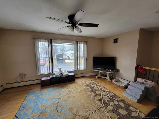 living room with light hardwood / wood-style floors, ceiling fan, and baseboard heating