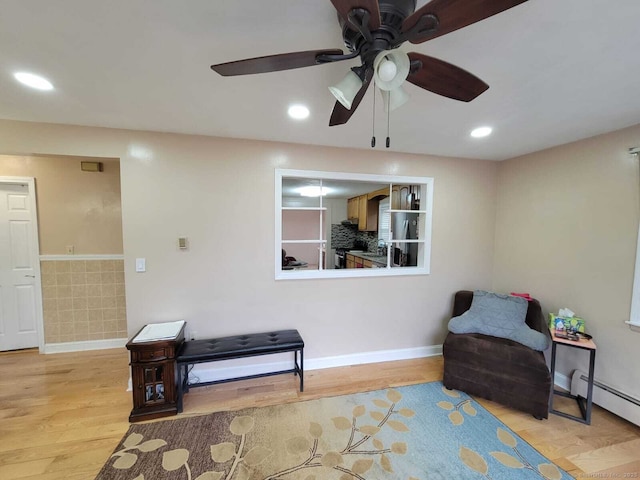 sitting room featuring a baseboard radiator and light wood-type flooring