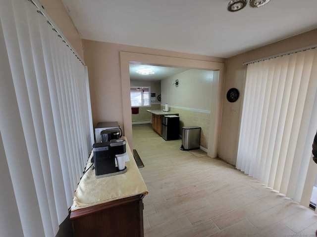 corridor featuring light hardwood / wood-style floors and a baseboard heating unit