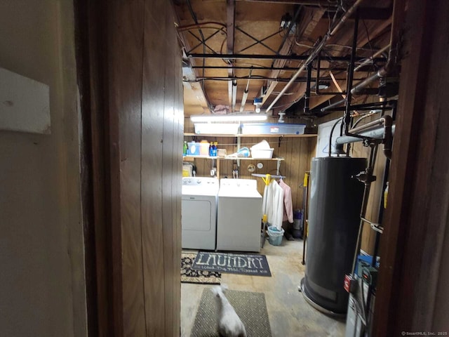 basement with washer and dryer, water heater, and wood walls