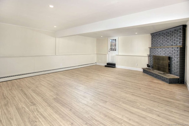 unfurnished living room with a fireplace, light wood-type flooring, and baseboard heating