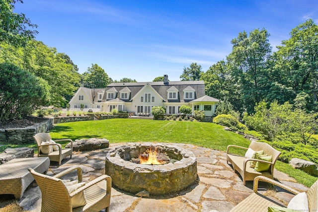 back of property featuring a yard, a fire pit, and a patio area