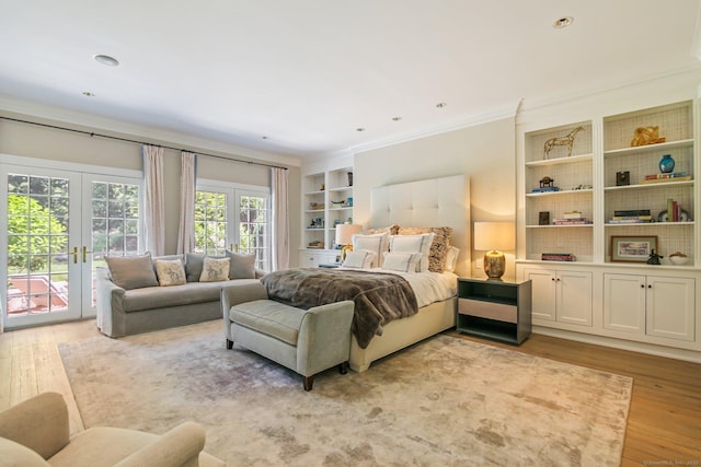 bedroom with crown molding, access to exterior, light wood-type flooring, and french doors