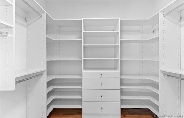 walk in closet with wood finished floors