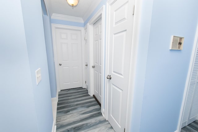 hallway with ornamental molding and dark hardwood / wood-style flooring